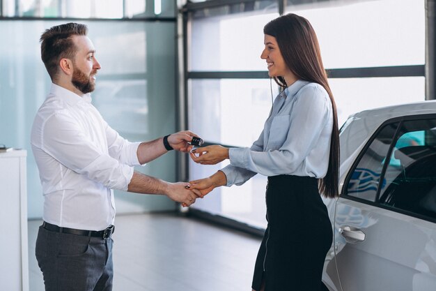 Salesman and woman looking for a car in a car showroom