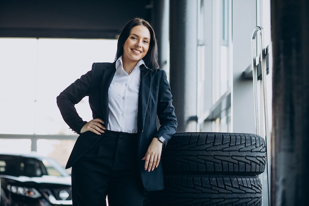 Free photo saleswoman in car showroom selling cars