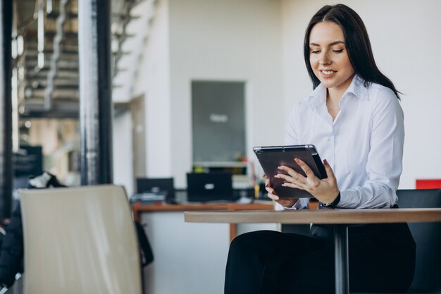 Saleswoman in car showroom selling cars