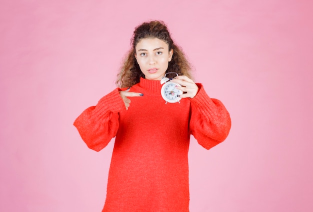 A saleswoman holding and promoting new alarm clock.