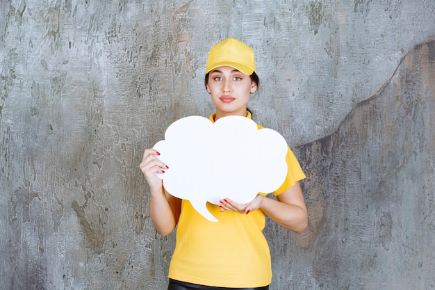 Free photo a saleswoman in yellow uniform holding a cloud shape info board