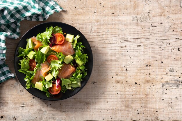 Salmon and avocado salad on rustic wooden table