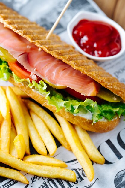 フライドポテトとケチャップを添えたサーモンバーガー