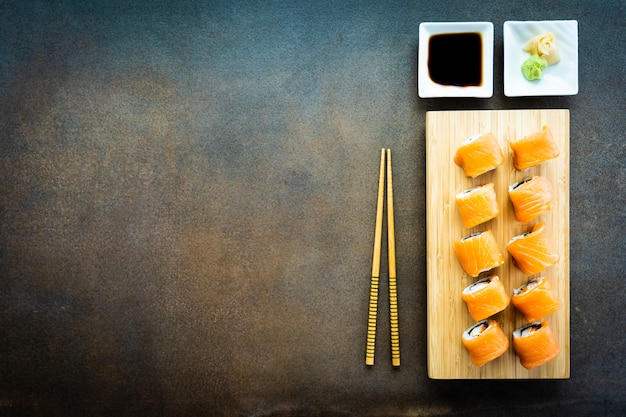 Salmon fish meat sushi roll maki on wood plate