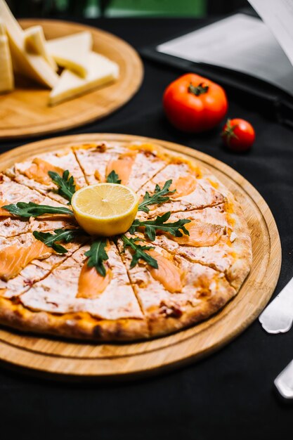 Salmon pizza with sauce rocket and lemon