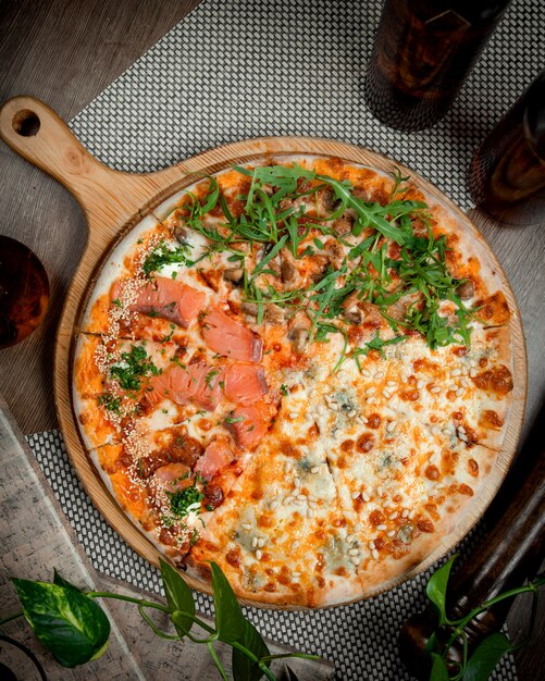 テーブルの上の野菜とサーモンのピザ