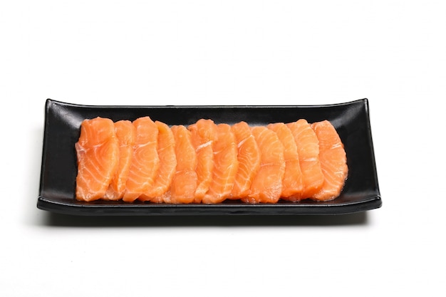 salmon slices in black plate on white background