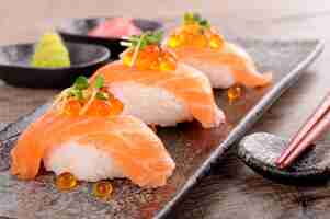 Free photo salmon sushi with caviar and chopsticks