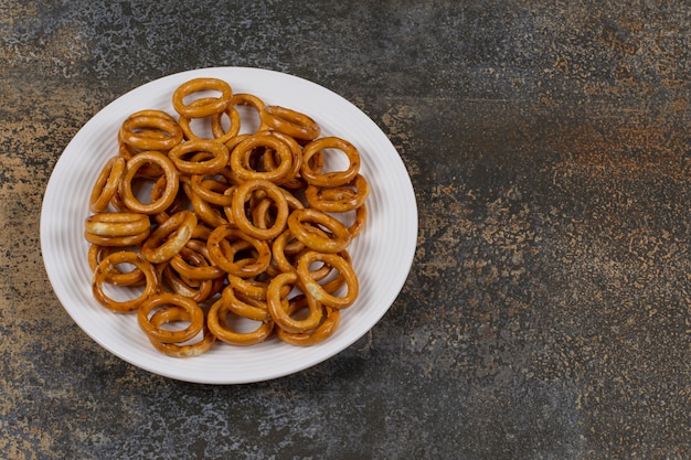 Salted circle pretzels on white plate.