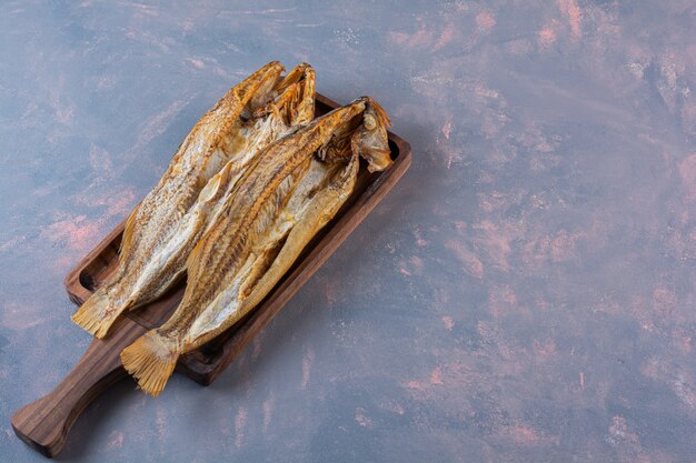 Salted fish on a board, on the marble surface