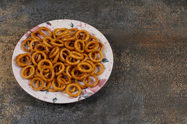 Salted pretzel rings on colorful plate. 