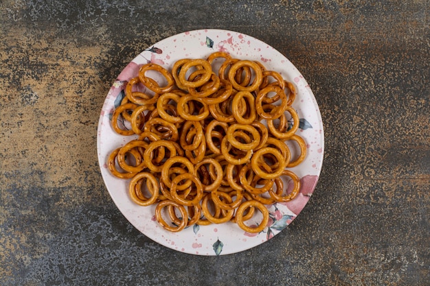 Salted pretzel rings on colorful plate. 