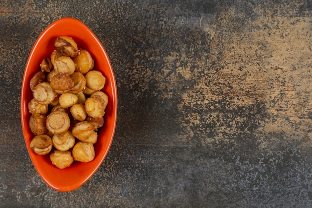 Free photo salted tasty crackers in orange bowl.