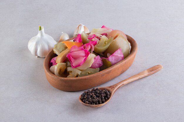 Salty cabbage in gray tray placed on stone table. 