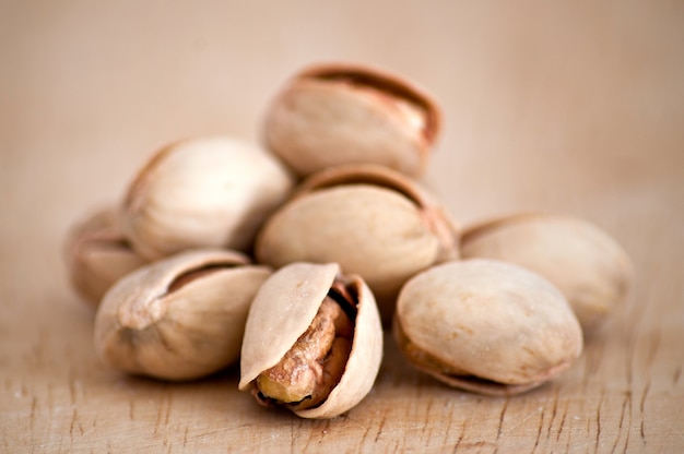 Salty nuts of roasted pistachio on an old wooden table.