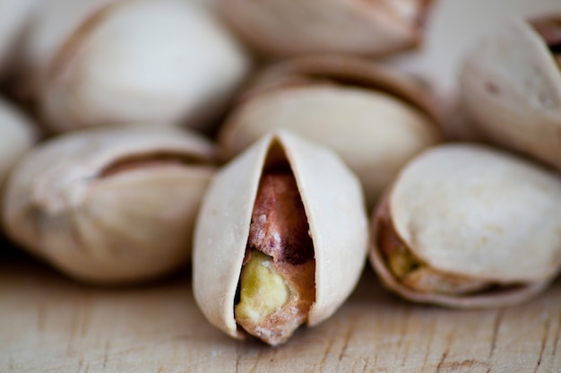 Salty nuts of roasted pistachio on an old wooden table.