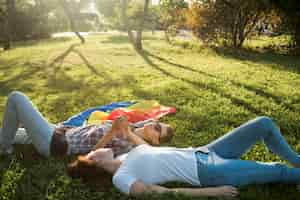 Free photo same-sex couple lying in park