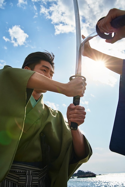 Foto gratuita samurai che combatte con le spade all'aperto