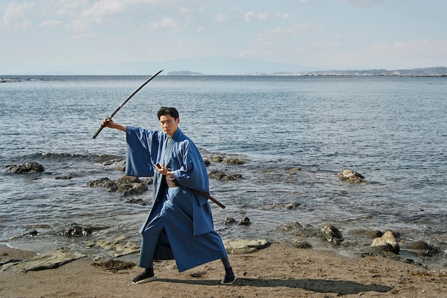 Бесплатное фото Самурай с мечом на пляже