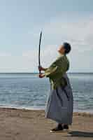 Free photo samurai with sword at the beach