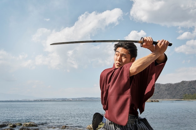 Free photo samurai with sword at the beach