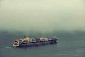Free photo san francisco, ca - may 11: cargo ship pass by san francisco bay in fog on may 11, 2014 in san francisco. sf is the most densely settled large city in california and the second-most in us.