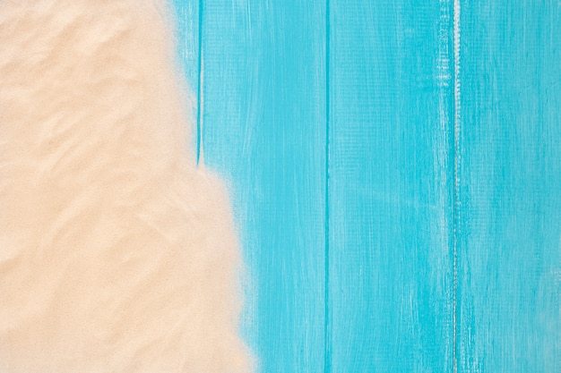 Sand border on blue wooden background with copy space