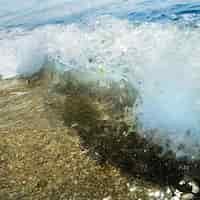 Foto gratuita pietre di sabbia e onda d'acqua