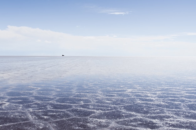 Sand texture visible under the crystal clear sea and the sky