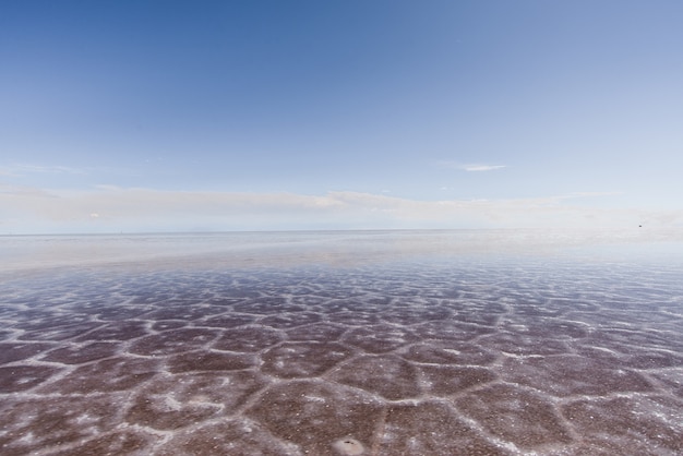 Sand texture visible under the crystal clear sea and the sky
