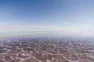 Free photo sand texture visible under the crystal clear sea and the sky