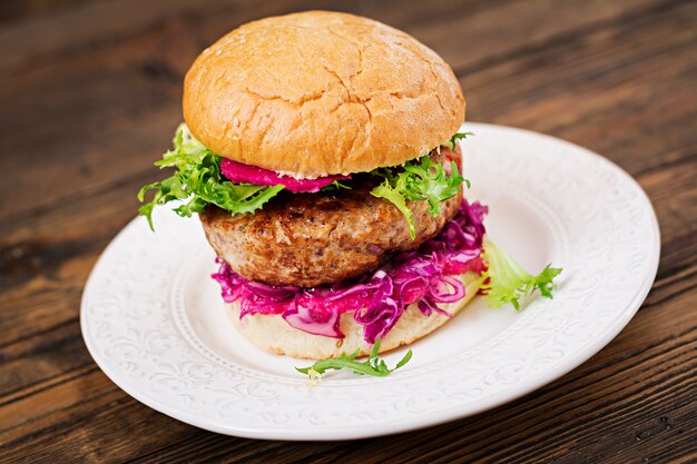 Sandwich hamburger with juicy burgers, red cabbage and pink sauce