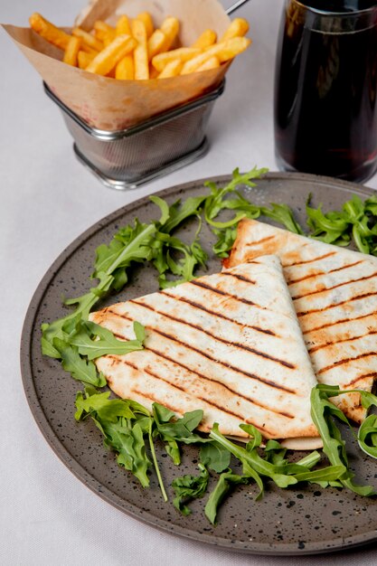 Sandwich in lavash served with arugula french fries