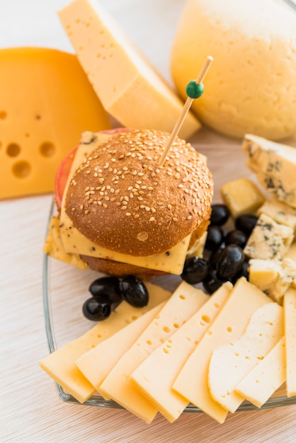 Бутерброд рядом с сыром и оливками на тарелке