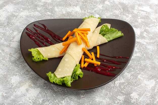 sandwich rolls with vegetables and green salad along with rusks inside dark plate