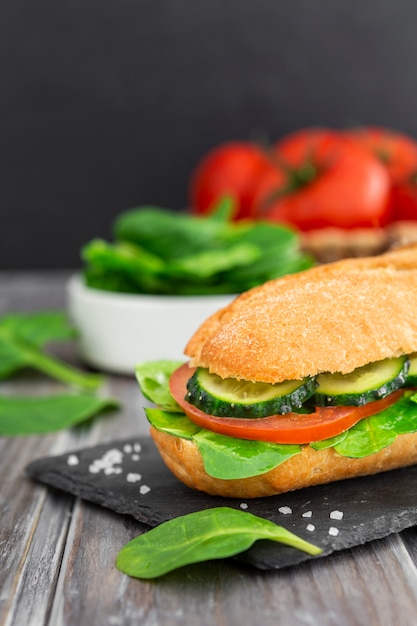 Sandwich on slate with cucumber slices and spinach