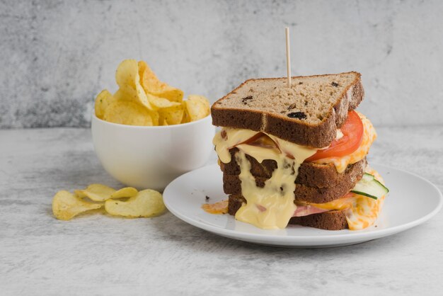 Sandwich with bowl with chips beside