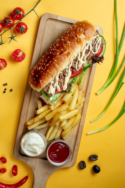 Foto gratuita panino con carne tritata e patatine fritte