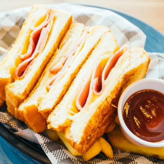 Sandwich with ham cheese and french fries and tomato sauce