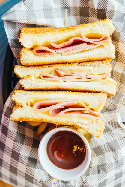 Sandwich with ham cheese and french fries and tomato sauce