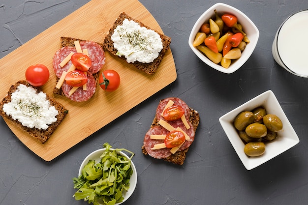 Бутерброды на разделочной доске с оливками