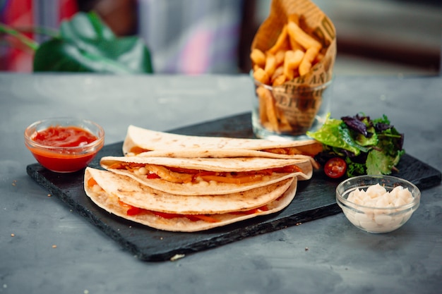 Panini al lavash con salsa di pomodoro, insalata verde e patatine fritte.