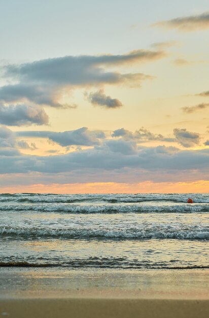 Sandy beach sunset over the sea with colorful clouds orange sunlight Vertical frame autumn sunsets early autumn velvet season The idea of a background or splash screen