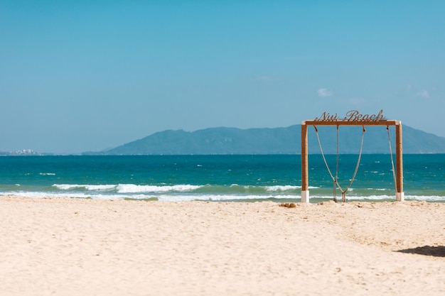 Sandy beach with decorative wooden arch near sea