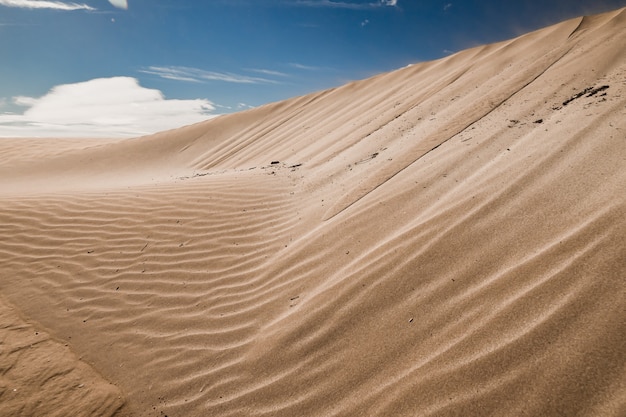 Sandy hills in a deserted area with traces left by the wind