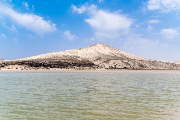 Foto gratuita riva sabbiosa vicino ad acque calme