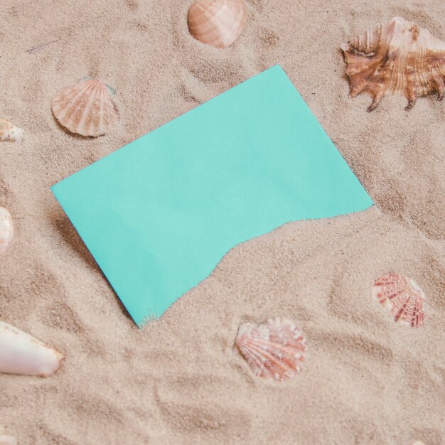 Sandy surface with paper and seashells