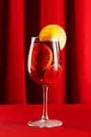 Free photo sangria drink with lemon slice on red background