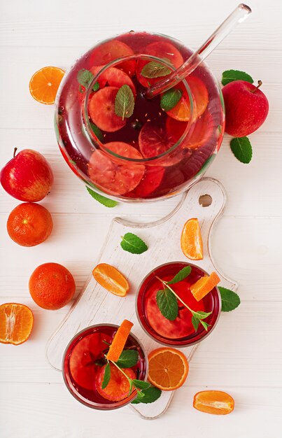 Sangria with fruits and mint on a white