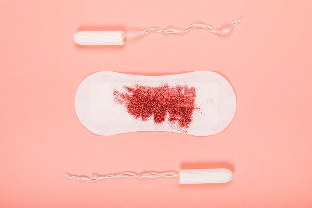 Foto gratuita asciugamano sanitario con glitter e tamponi